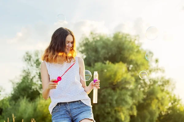 Happy cheerful smiling girl teenager 15, 16 years old with soap bubbles — Stock Photo, Image