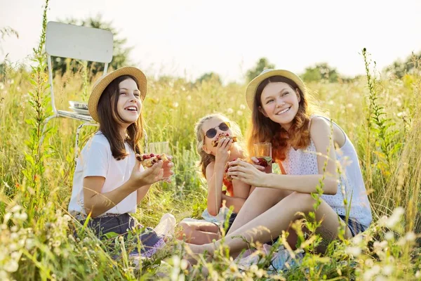 Šťastné dívky děti jíst jahodový koláč a pití čaje s mátovými bobulemi na piknik — Stock fotografie