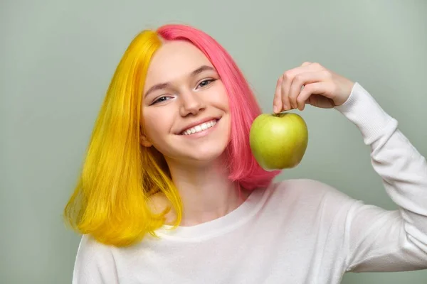 Hlava záběr krásné usmívající se dospívající dívka s bílým úsměvem se zuby, drží jablko — Stock fotografie