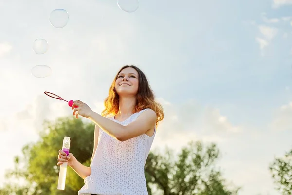 Šťastný veselý úsměv dívka teenager 15, 16 let s mýdlové bubliny — Stock fotografie