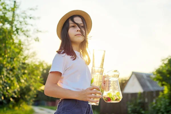 Flicka med kanna med hemmagjord jordgubbsmintdryck och tomma glas — Stockfoto