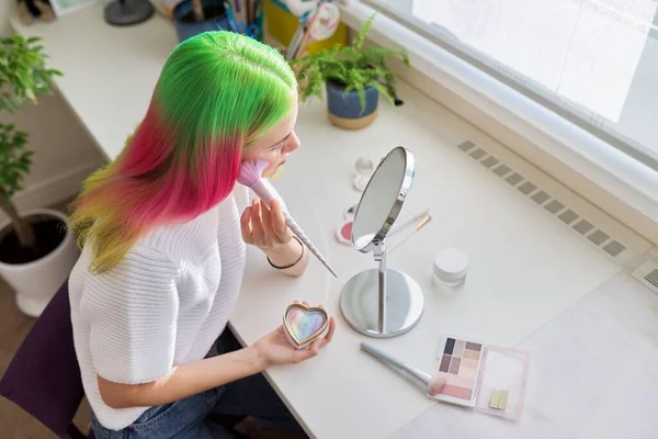 Chica adolescente con el pelo teñido haciendo maquillaje mirando en el espejo —  Fotos de Stock