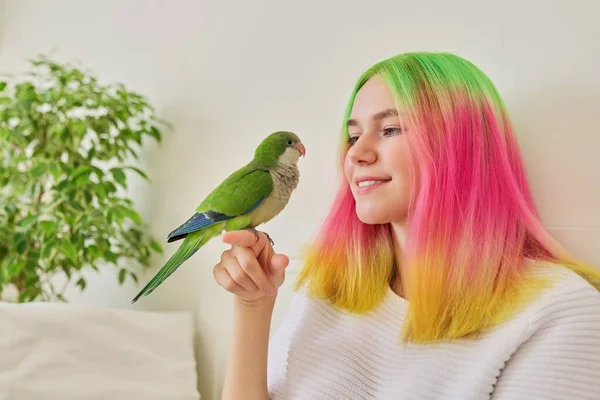 Trendig tonåring flicka med grön papegoja på handen — Stockfoto