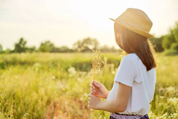 Été nature, vue arrière de l'enfant fille en chapeau de paille déchirant prairie herbes — Photo