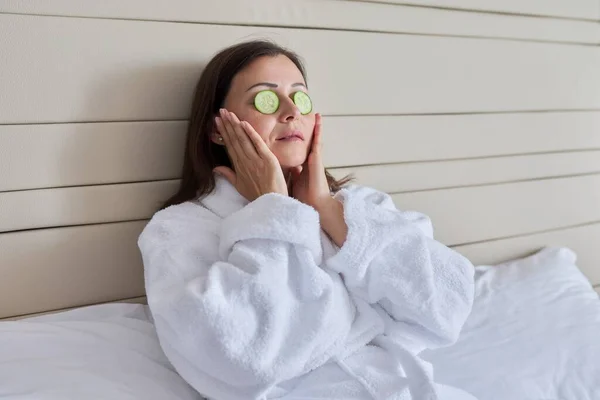 Reife Frauen im Bademantel bei Wellness-Behandlungen zu Hause mit Gurken — Stockfoto