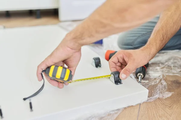 Montagem de móveis de madeira branca em casa, carpinteiros mãos com ferramentas e fita métrica — Fotografia de Stock