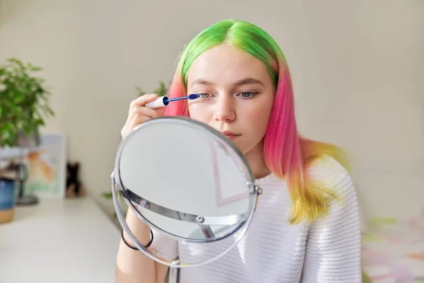 Menina adolescente com cabelos tingidos coloridos tingir pestanas com rímel — Fotografia de Stock