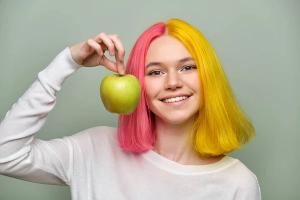 Hlava záběr krásné usmívající se dospívající dívka s bílým úsměvem se zuby, drží jablko — Stock fotografie