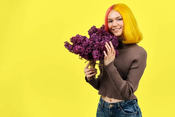 Tonårstjej med färgat rosa gult hår som håller lila blommor i händerna, kopiera utrymme — Stockfoto