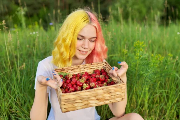 Leende tonåring flicka med jordgubbar i korgen, trädgård natur bakgrund — Stockfoto