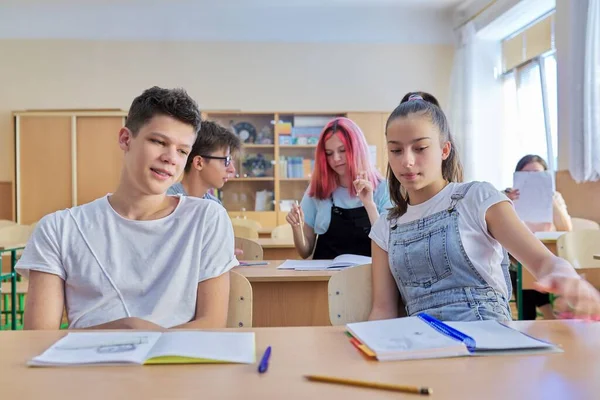School, onderwijs, adolescentie. Groep tienerkinderen zittend aan een bureau in de klas — Stockfoto