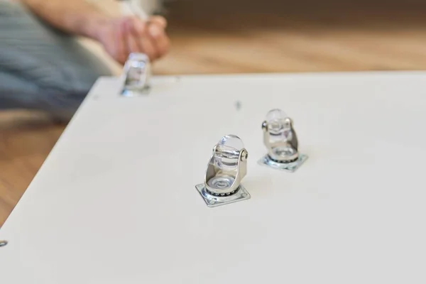 Furniture wheels close-up. Worker hands assembling furniture using professional tool — Stock Photo, Image