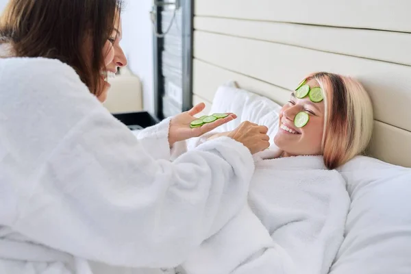 Mutter und Teenager-Tochter pflegen Gesicht mit Naturkosmetik und Gurke — Stockfoto