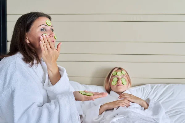 Mutter und Teenager-Tochter pflegen Gesicht mit Naturkosmetik und Gurke — Stockfoto