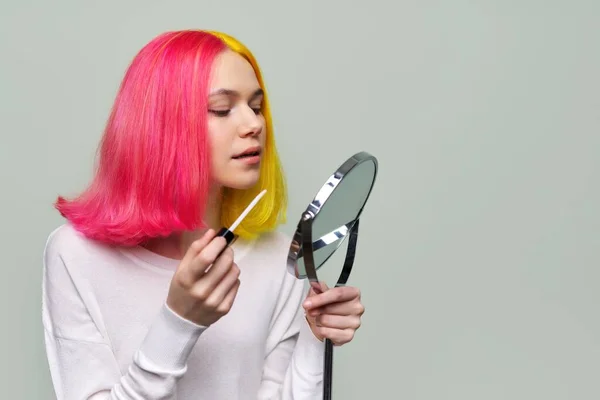 Adolescente de menina na moda com espelho de lábios de pintura de maquilagem com lustro — Fotografia de Stock