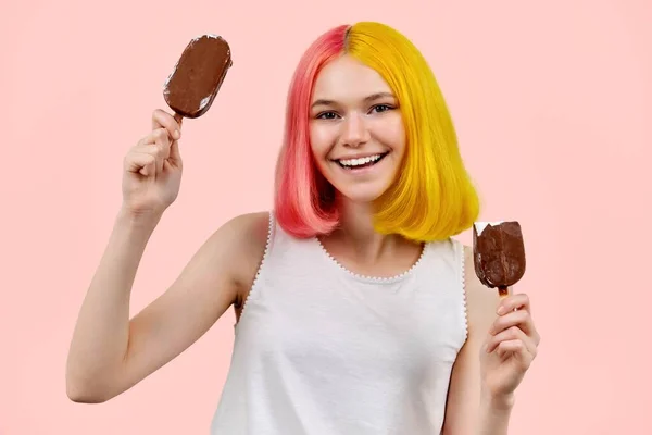 Bella ragazza adolescente sorridente con delizioso gelato al cioccolato su sfondo rosa — Foto Stock