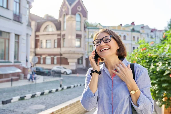 성숙 한 사업을 하는 여자가 시내를 걷는 핸드폰으로 얘기하는 모습 — 스톡 사진