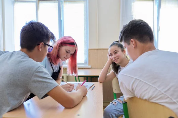 School, onderwijs, adolescentie. Groep tienerkinderen zittend aan een bureau in de klas — Stockfoto