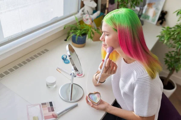 Chica adolescente con el pelo teñido haciendo maquillaje mirando en el espejo —  Fotos de Stock