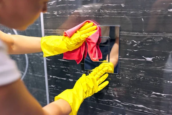 Limpeza do banheiro, mulher em luvas com telhas de polimento de pano e acessórios cromados — Fotografia de Stock