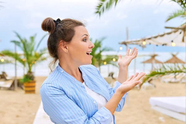 Позитивная женщина-консультант по путешествиям на приморском курорте, разговаривающая с веб-камерой — стоковое фото