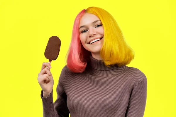 Fashionabel flicka med choklad glass på pinne på gul bakgrund — Stockfoto