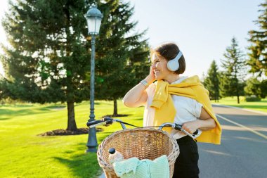 Parkta bisiklet süren güzel, aktif, olgun bir kadın.