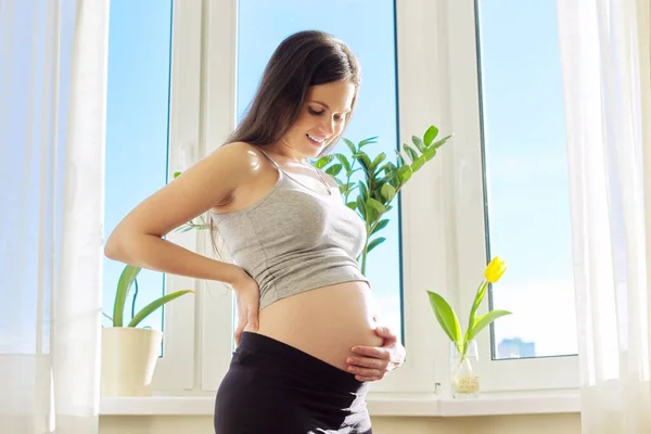 Young beautiful pregnant woman touching her belly with love — Stock Photo, Image