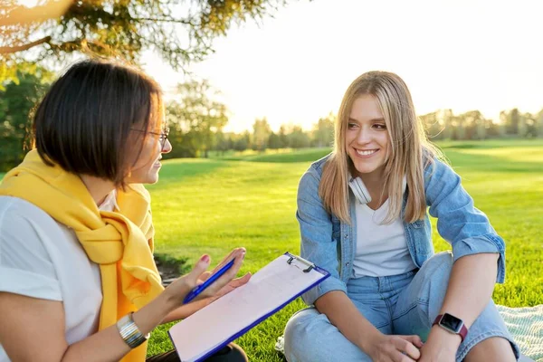 Conversación de la joven con el psicólogo, trabajador social, al aire libre en la reunión en el parque en el césped — Foto de Stock