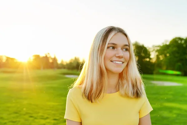 노란 티셔츠를 입은 16 세, 17 세, 청명 한 잔디 위에서 웃는 10 대 소녀의 실외 사진 — 스톡 사진