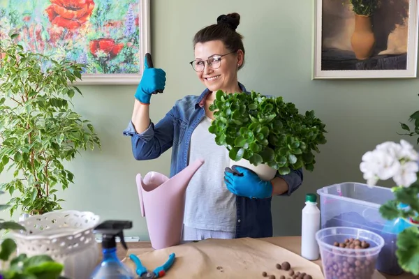 Vrouw met thuis planten in potten, met de hand ok gebaar — Stockfoto