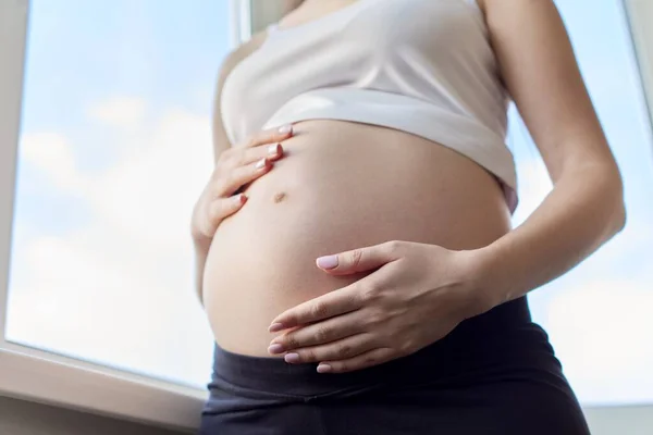 Young beautiful pregnant woman touching her belly with love — Stock Photo, Image