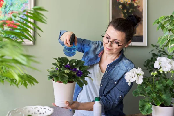 Vrouw die zorgt voor binnenplanten, hobby 's en vrije tijd, natuur in huis — Stockfoto