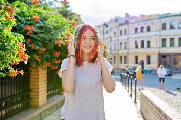 Módní dospívající dívka v bezdrátových sluchátkách s jasně barvený barevný účes — Stock fotografie