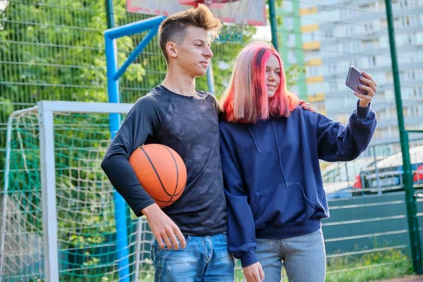 Paar tieners met basketbal op straat rechter het nemen van selfie foto met behulp van smartphone — Stockfoto