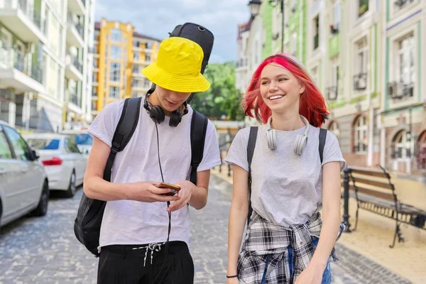 Tonåringar kille och flicka promenader och prata längs stadens gata med gitarr i fall — Stockfoto