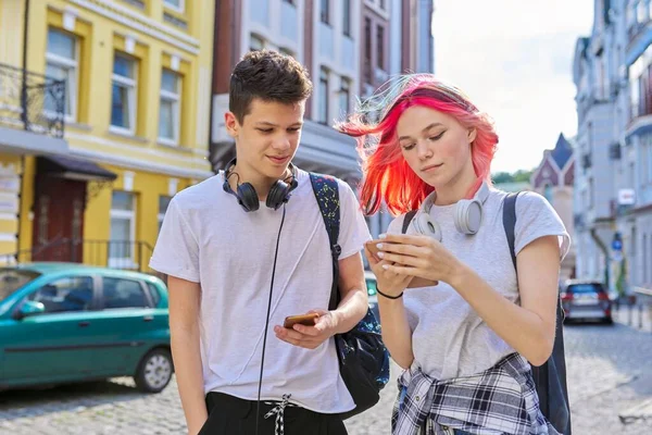 Pareja de adolescentes de moda amigos con teléfono inteligente en la calle de la ciudad —  Fotos de Stock