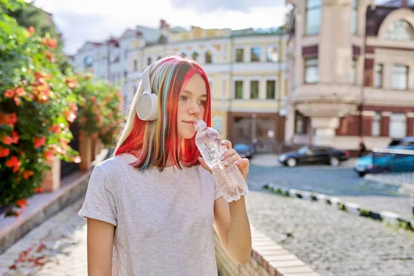 Léto, teplo ve městě, mladá žena s lahví vody — Stock fotografie