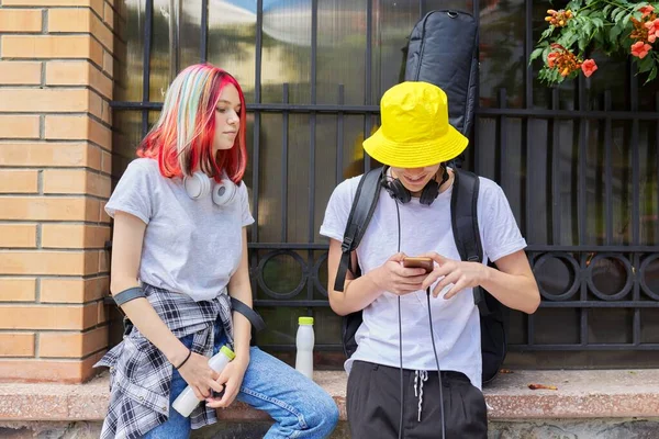 Пара трендовых подростков друзей со смартфоном на городской улице — стоковое фото