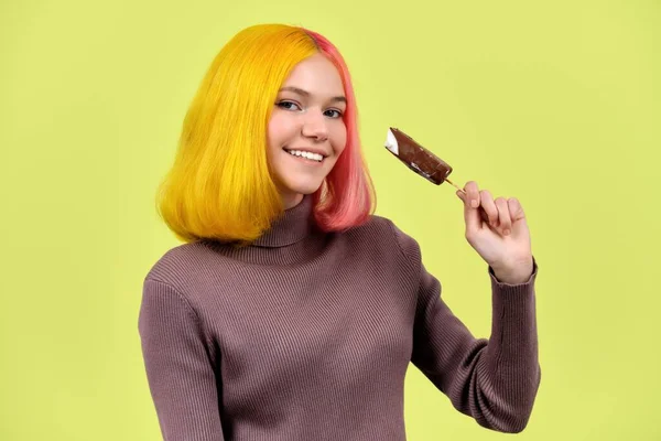 Jovem bela modelo adolescente com sorvete de chocolate em sua mão no fundo amarelo — Fotografia de Stock
