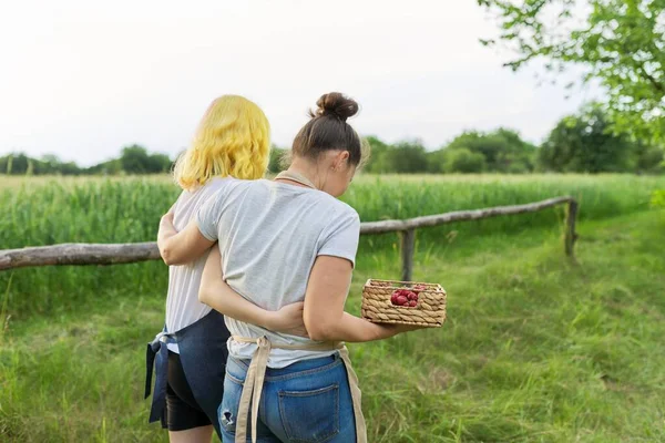 Tillbaka syn på vandrande mor och tonårsdotter kramas tillsammans på gården — Stockfoto