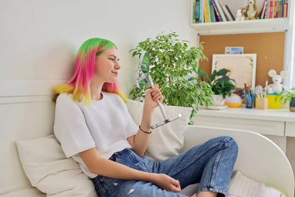 Modieus tiener meisje zitten thuis op bed op zoek in spiegel — Stockfoto