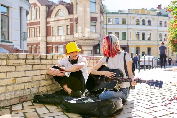 Happy young people couple guy and girl playing acoustic guitar — Stock Photo, Image