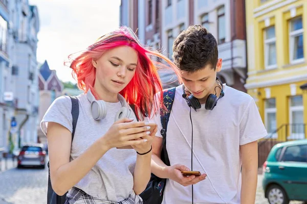 Pareja de adolescentes de moda amigos con teléfono inteligente en la calle de la ciudad —  Fotos de Stock