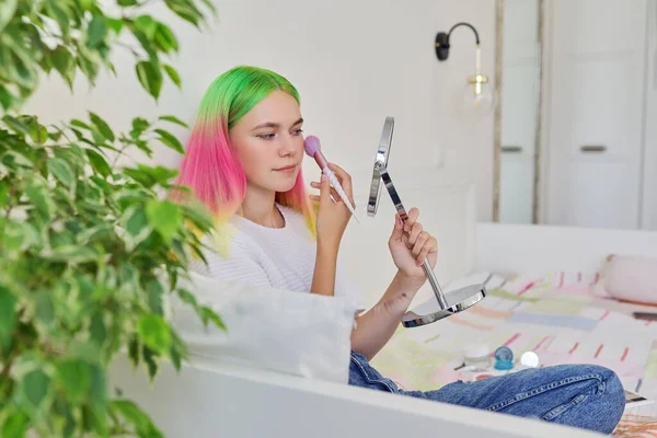 Modieus tiener model met gekleurd geverfd haar doen make-up met behulp van spiegel borstel — Stockfoto