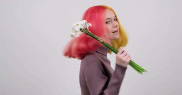 Schöne lächelnde Teen-Modell mit Strauß von weißen Narzissen auf hellem Hintergrund — Stockvideo