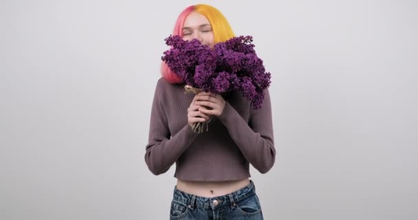 손에 라일락 꽃을 들고 보라색 머리를 염색 한 10 대 소녀 — 비디오