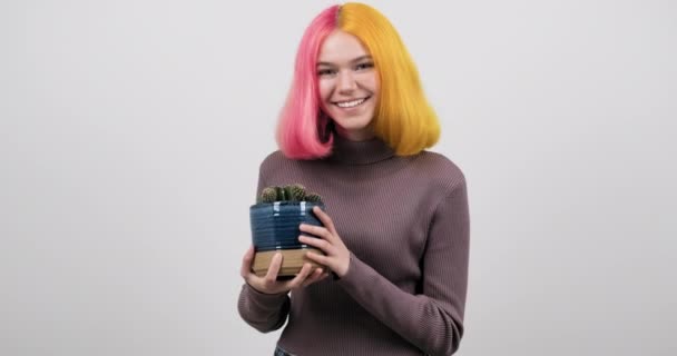 Sonriente chica adolescente feliz con pelo de colores sosteniendo la olla con cactus — Vídeos de Stock