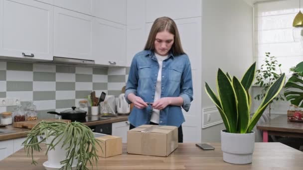 Joven mujer feliz desembalaje cajas de cartón, unboxing paquete postal esperado — Vídeos de Stock