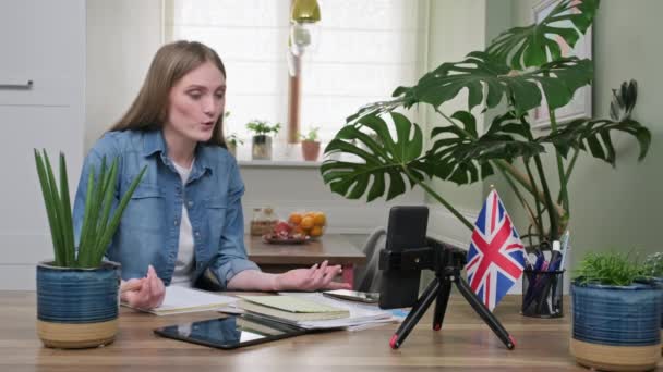 Brittiska lära sig engelska online. Kvinnlig student på distans tittar på webbkamera — Stockvideo